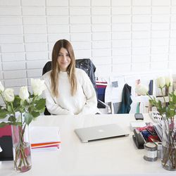 Designer Alexander at her desk in her all-white-everything office.