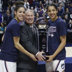 UConn’s Kia Nurse (11) and Gabby Williams (15) accept the AAC Championship Trophy from AAC commissioner Mike Aresco.