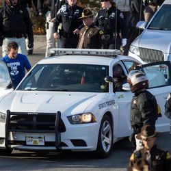 Mike Ellsworth, the brother of Utah Highway Patrol Trooper Eric Ellsworth, second from left, gets into Trooper Ellsworth's patrol car as Ellsworth's body is transported from the State Medical Examiner's Office in Salt Lake City on Friday, Nov. 25, 2016.
