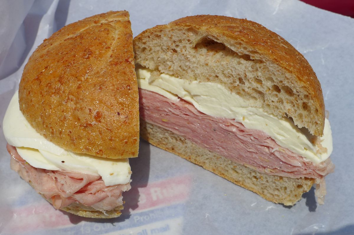 A sandwich on a round roll with lots of mortadella and fresh mozzarella, gleaming white.