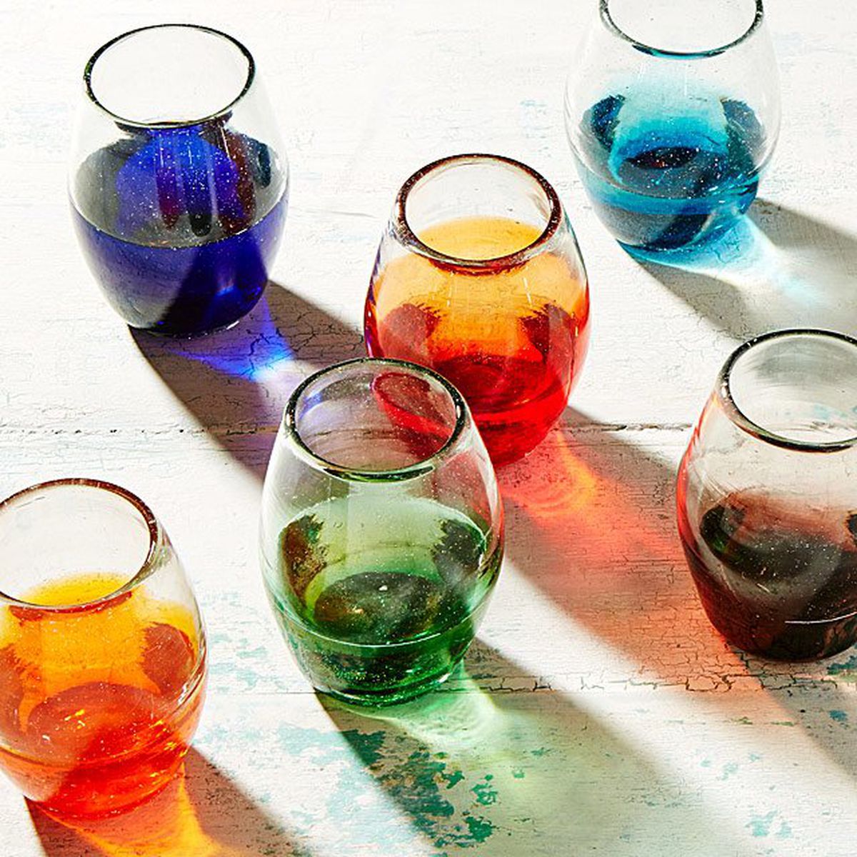 A series of glasses with colorful bottoms. 