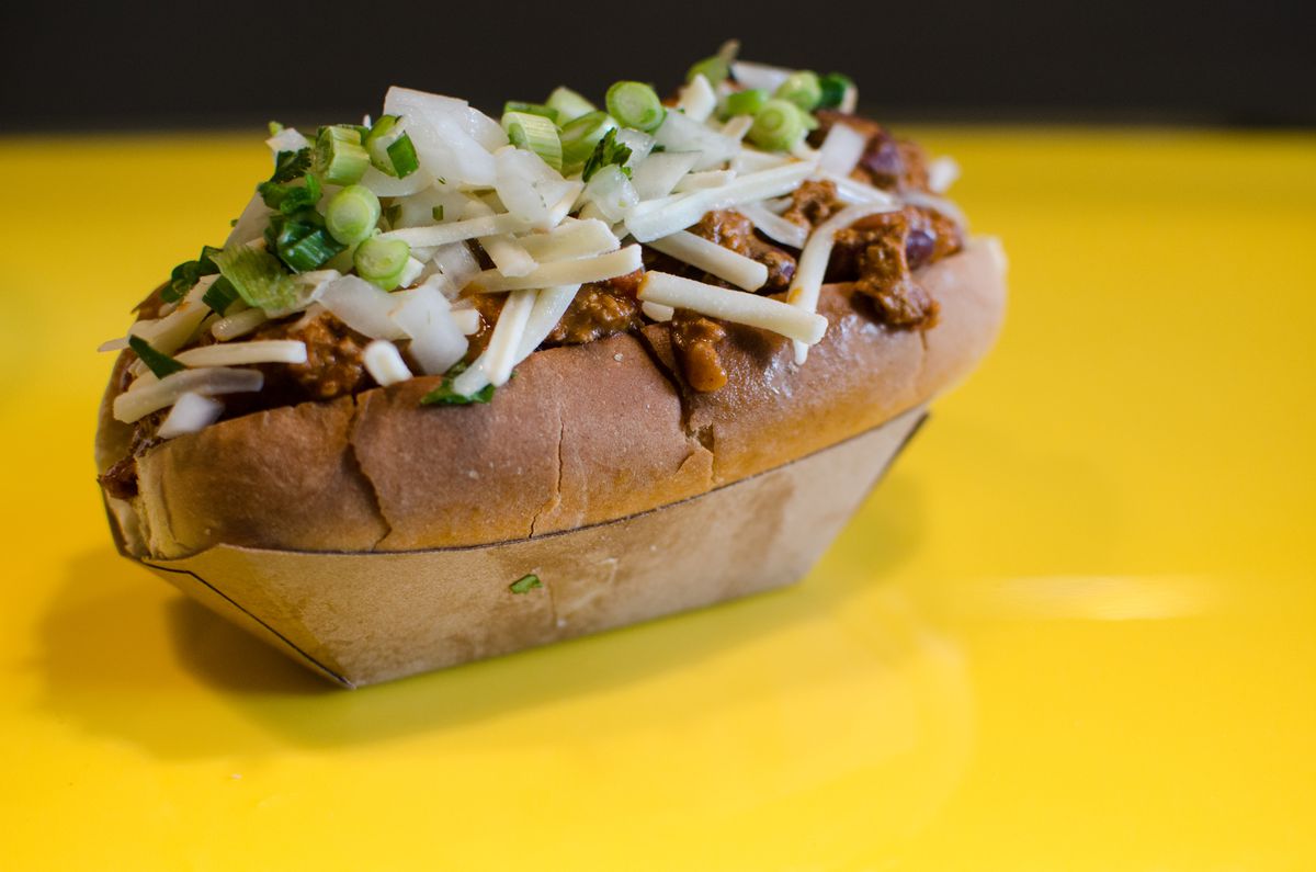 At Saus’s all-vegetarian location in Somerville, the chili-cheese dog, pictured here on a bright yellow counter, is made with Beyond sausage