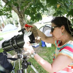 Renee Coovert, of Houston, Texas, assembles a DIY eclipse filter holder for the end of her telescope as she prepares for viewing Monday's total solar eclipse at Weiser High School in Weiser, Idaho, on Sunday, Aug. 20, 2017.