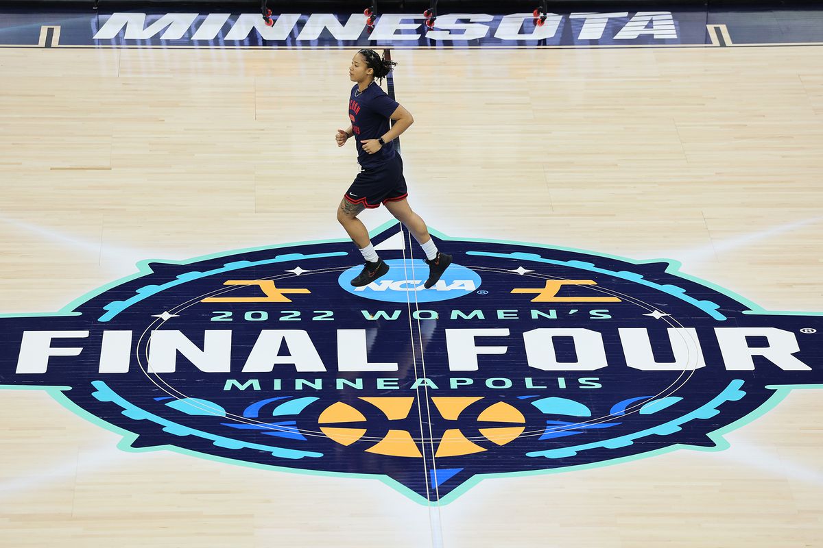 A member of the UConn Huskies staff runs over the logo for the Women’s Final Four tournament during a practice session at Target Center on March 31, 2022 in Minneapolis, Minnesota. The UConn Huskies will play the Stanford Cardinal on April 1, 2022.