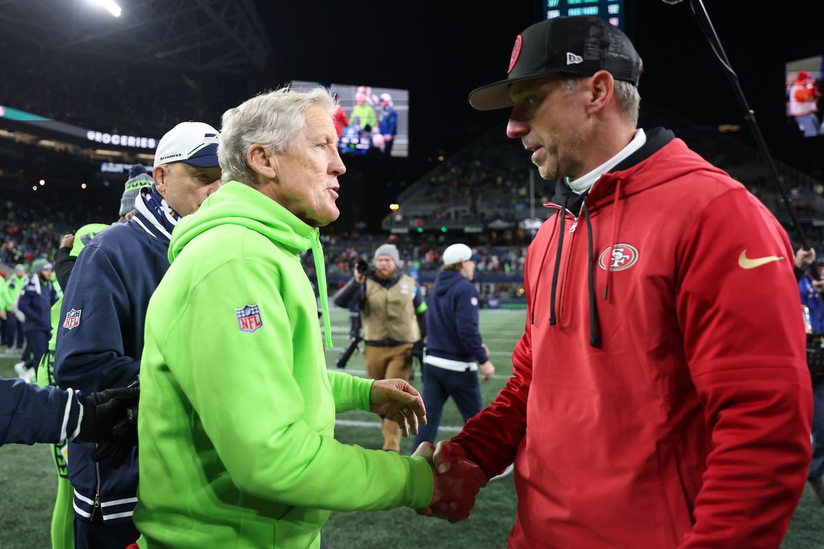 Head coach Pete Carroll of the Seattle Seahawks and head coach Kyle Shanahan of the San Francisco 49ers shake hands after a game at Lumen Field on November 23, 2023 in Seattle, Washington.
