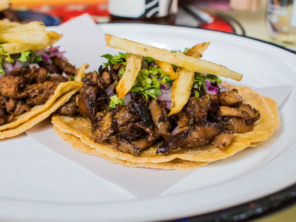 Two tacos topped with seitan steak.