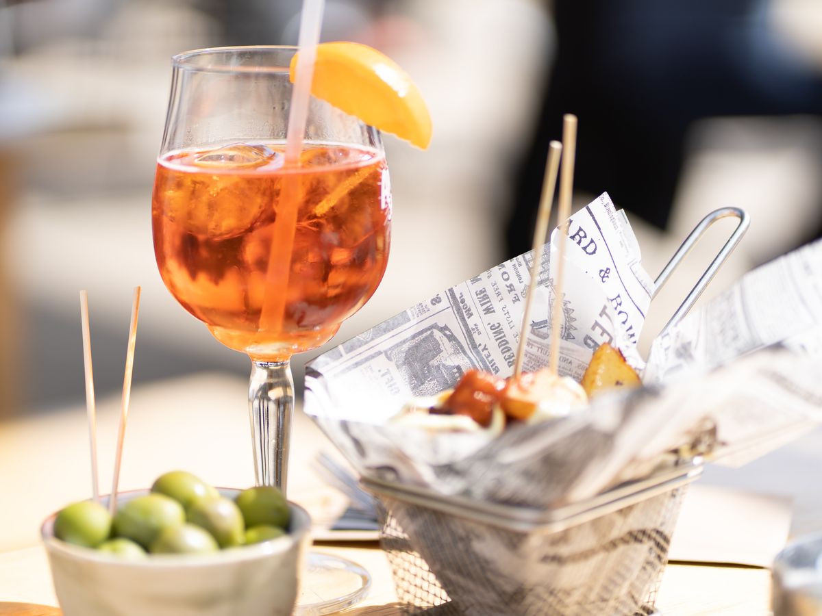 aperol spritz and food on a table.
