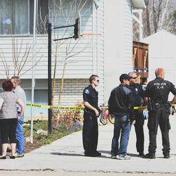 Residents and police stand in the driveway of a home in American Fork as police investigate a shooting Friday, April 5, 2013.