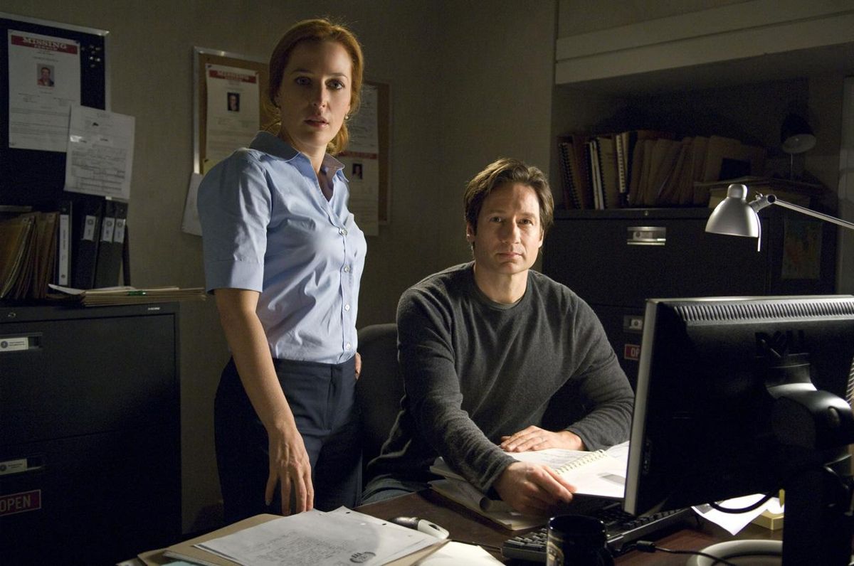 Gillian Anderson and David Duchovny at a desk in X-Files.