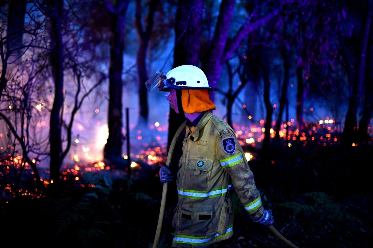 This photo taken on December 7, 2019 shows a firefighter conducting back burning measures to secure residential areas from encroaching bushfires at the Mangrove area, some 90-110 kilometres north of Sydney.