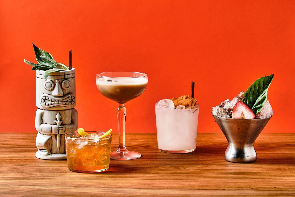 Tiki-looking cocktails against an orange background.