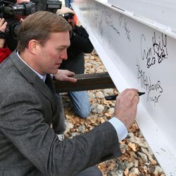 Salt Lake County Mayor Ben McAdams signs the last steel beam before it is raised into place atop the new district attorney office building in Salt Lake City on Tuesday, Dec. 6, 2016.