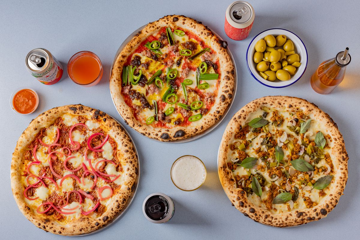 Three puffy cornicioned pizzas in a triangle, flanked by olives and spritz
