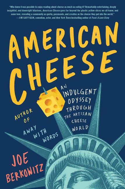 The cover of a book called American Cheese, featuring yellow text on a blue background, and the head of the statue of liberty with a piece of cheese stuck to one of the crown prongs