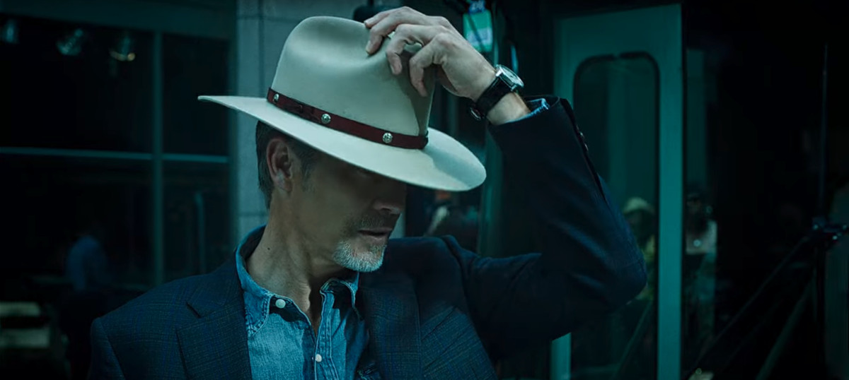Timothy Olyphant as an older Raylan Givens, putting on a new studded hat in Justified: City Primeval