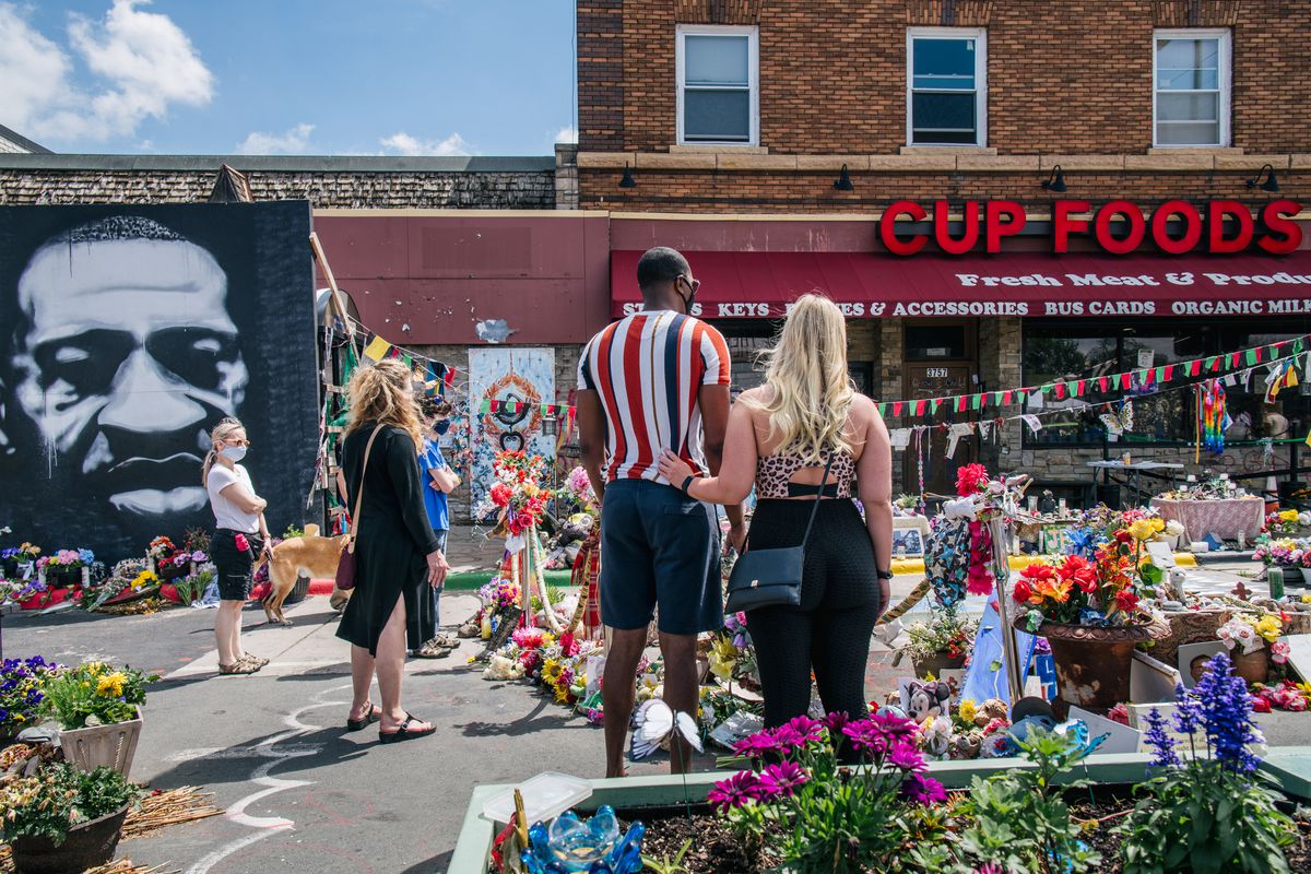 People pay their respects to George Floyd in the intersection of 38th Street and Chicago Avenue on May 25, 2021, in Minneapolis, Minnesota.