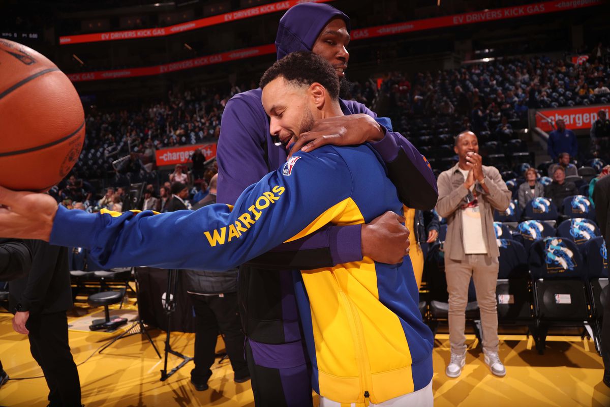Steph Curry hugging Kevin Durant in warmups.