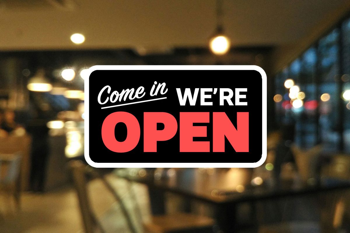 A sign reading “Come in, we’re open” overlays a blurred photograph of a dining room.