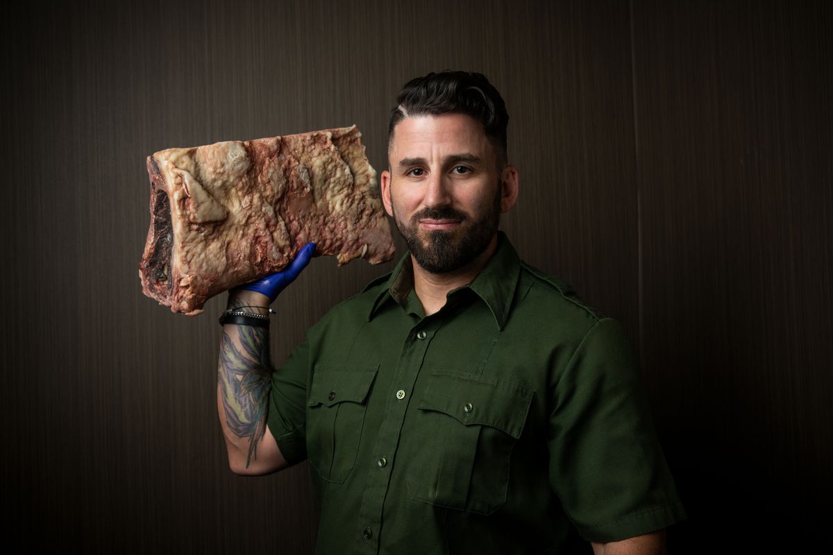 Chef Matthew Meyer hold a cut of dry-aged beef