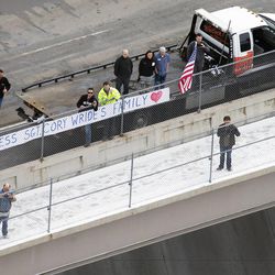 Onlookers watch from a freeway overpass as the procession passes on I-15, following funeral services for Utah County Sheriff's Sgt. Cory Wride Wednesday, Feb. 5, 2014.