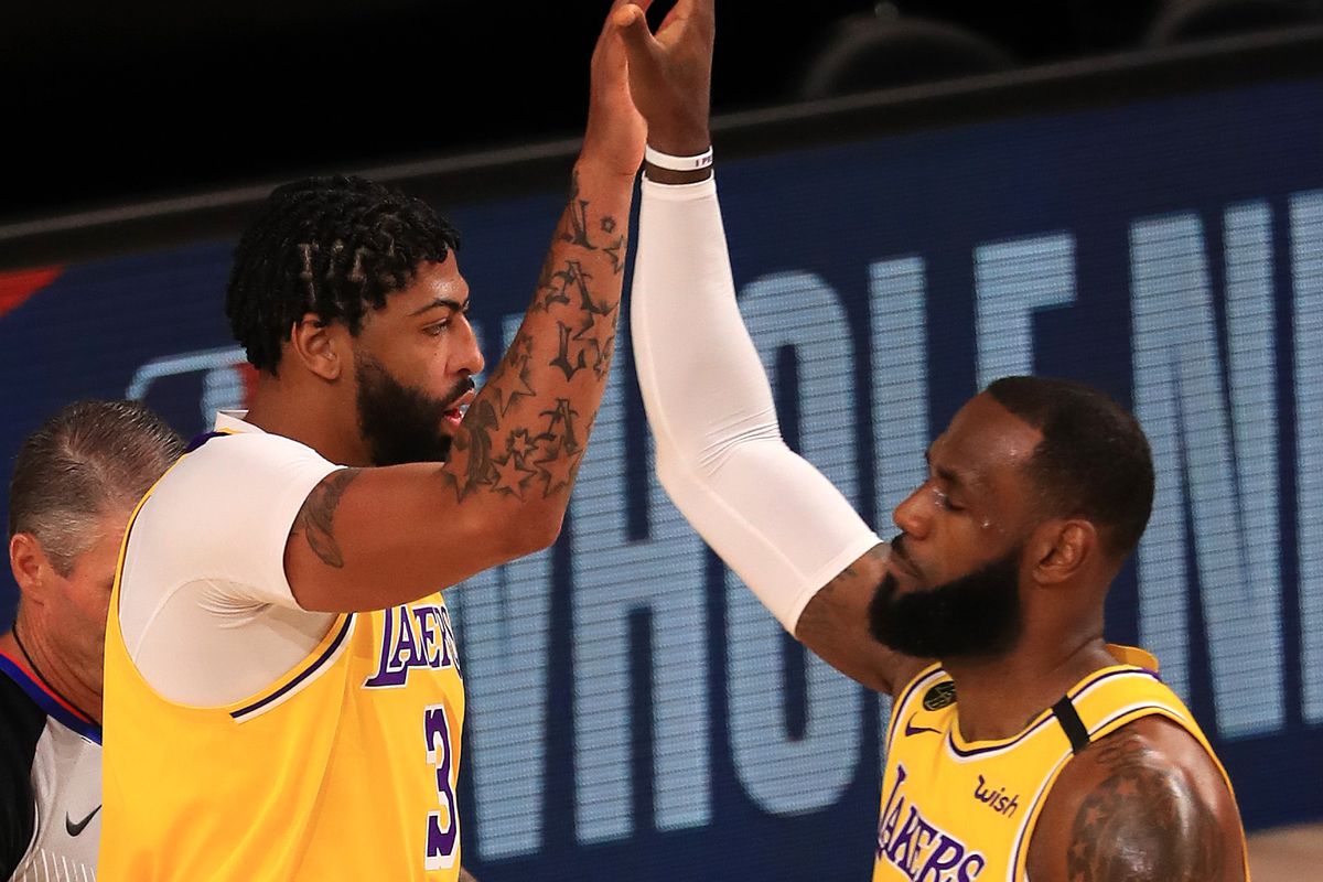 Anthony Davis and LeBron James of the Los Angeles Lakers high five against the LA Clippers during the first quarter of the game at The Arena at ESPN Wide World Of Sports Complex on July 30, 2020 in Lake Buena Vista, Florida.&nbsp;