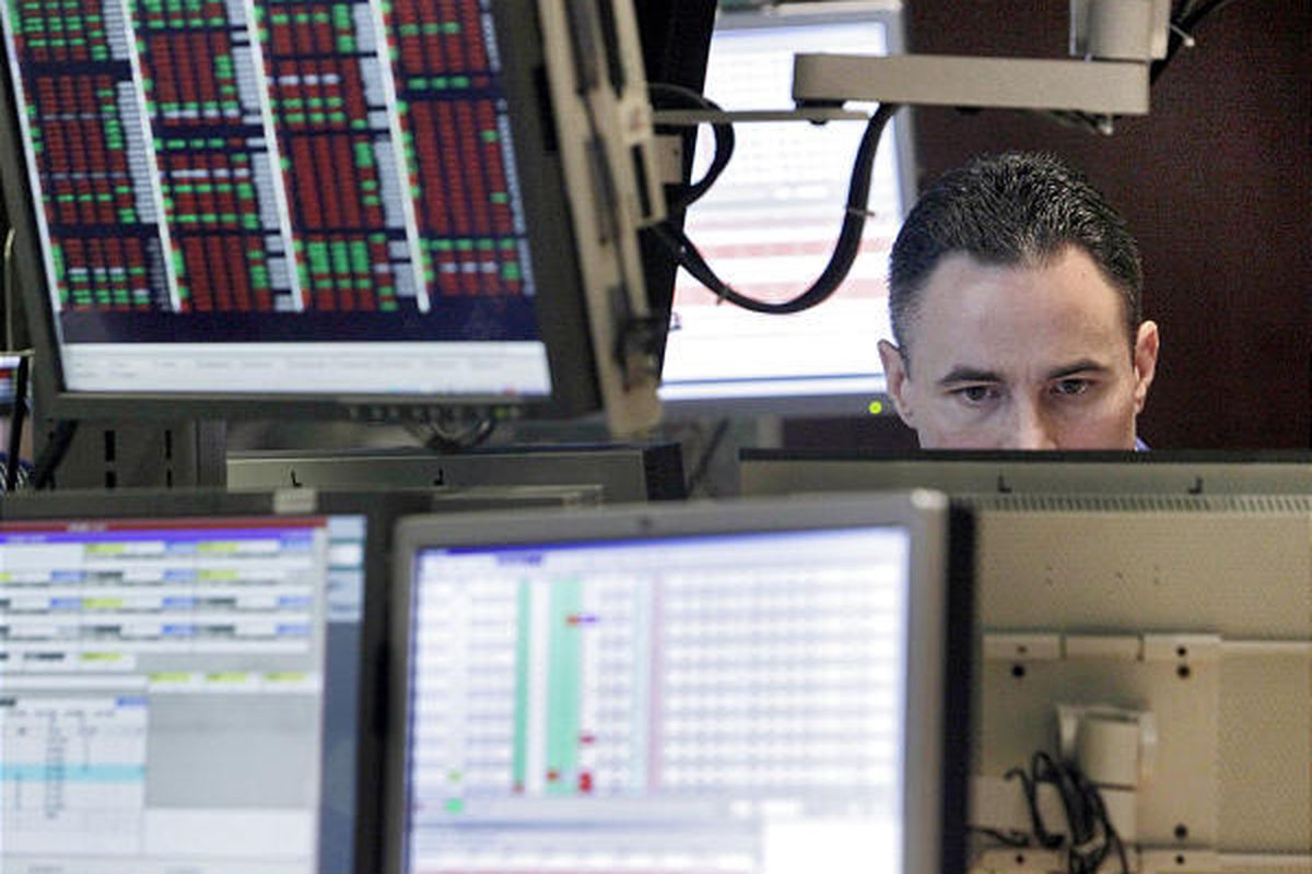 Jason Hardzewicz is surrounded by screens as he works on the floor of the NYSE.