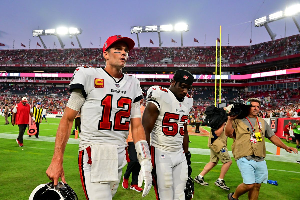 Tom Brady #12 and Olakunle Fatukasi #53 of the Tampa Bay Buccaneers walk off the field after being to defeated by the Green Bay Packers in the game at Raymond James Stadium on September 25, 2022 in Tampa, Florida.