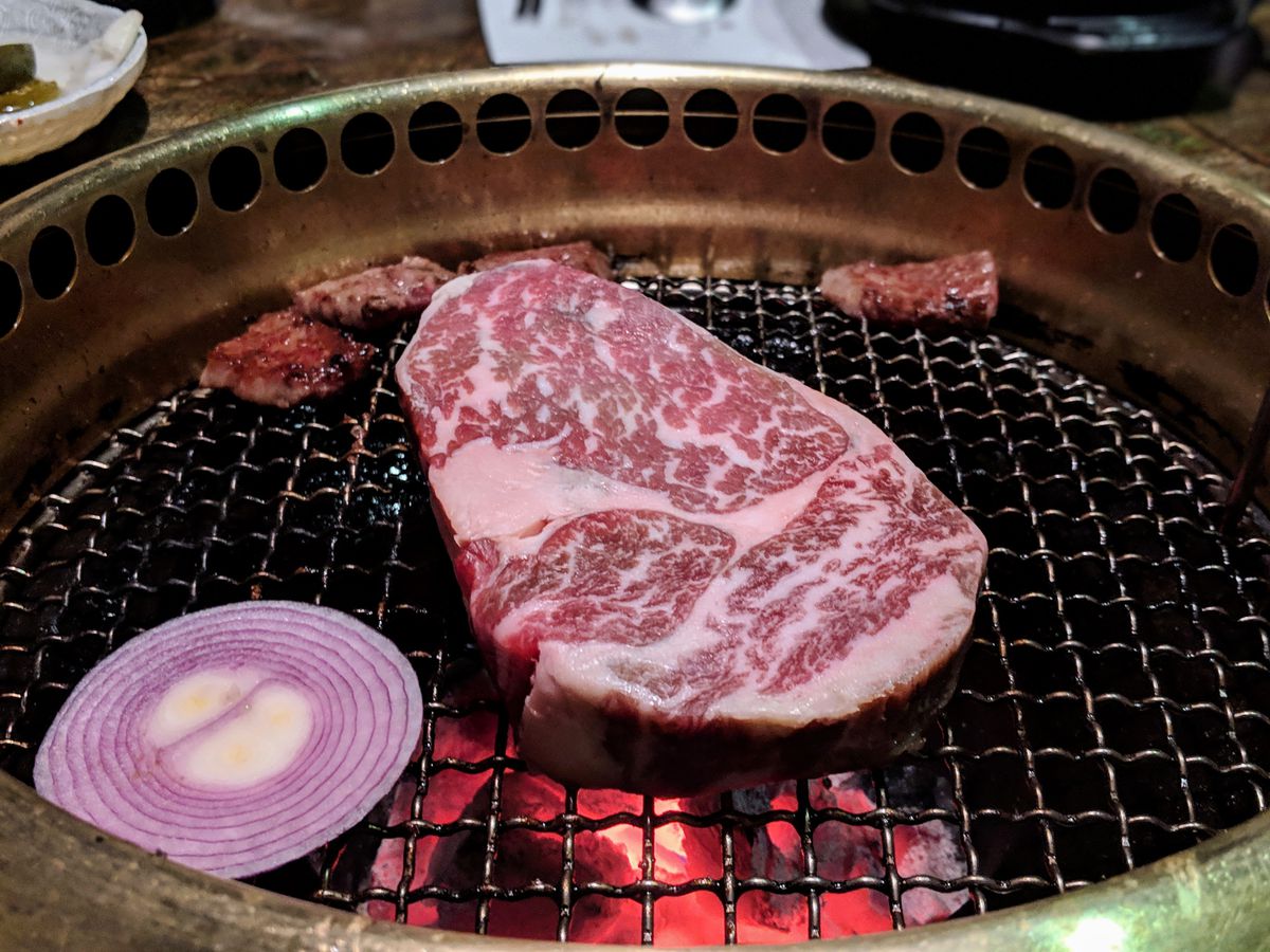 Prime ribeye beef on an open grate grill in Koreatown at Jeong Yuk Jeom.