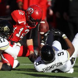 Utah quarterback Adam Schulz (12) gets tackled by Colorado defensive back Marques Mosley (17) and Colorado defensive back Tedric Thompson (9) during the second half of a football game at the Rice-Eccles Stadium in Salt Lake City on Saturday, Nov. 30, 2013. Utah won 24-17.