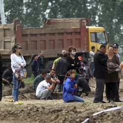 Residents look on as rescue efforts continue near a poultry processing plant that was engulfed by a fire in northeast China's Jilin province's Mishazi township on Monday, June 3, 2013. The massive fire broke out at the poultry plant early Monday, trapping workers inside a cluttered slaughterhouse and killing over a hundred people, reports and officials said.