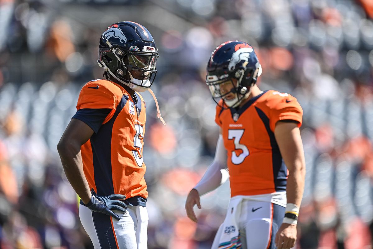 Teddy Bridgewater #5 and Drew Lock #3 of the Denver Broncos stand on the field during warm ups before a game against the Baltimore Ravens at Empower Field at Mile High on October 3, 2021 in Denver, Colorado.