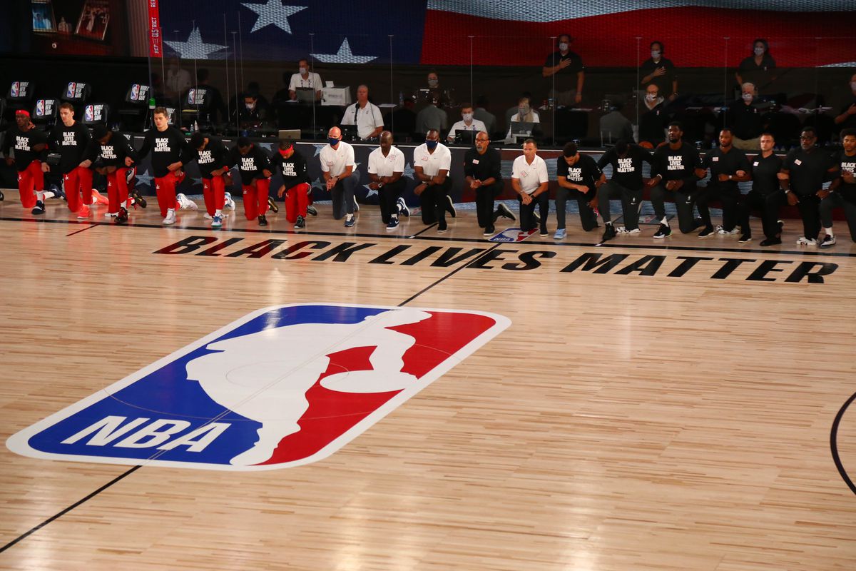 Phoenix Suns and Washington Wizards players kneel behind a Black Lives Matter logo on the court before a NBA basketball game in the Visa Athletic Center at the ESPN Wide World of Sports Complex.