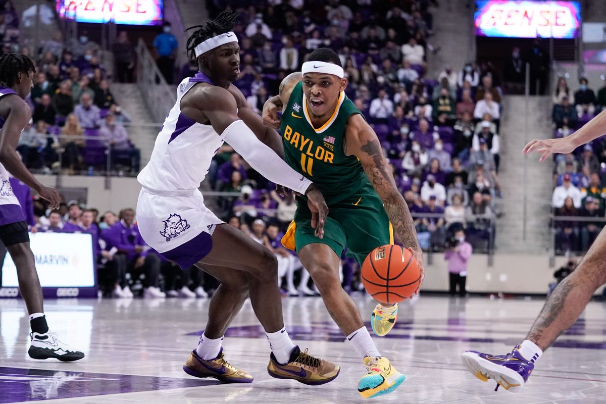 Baylor Bears guard James Akinjo drives to the basket against TCU Horned Frogs forward Emanuel Miller during the first half at Ed and Rae Schollmaier Arena.