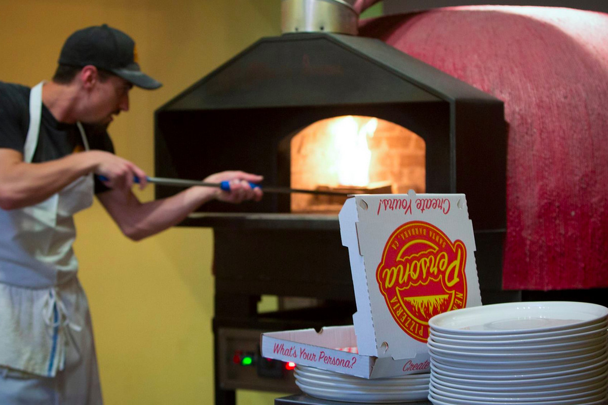 Persona fires up pizzas in a 800 degree imported wood-burning oven.