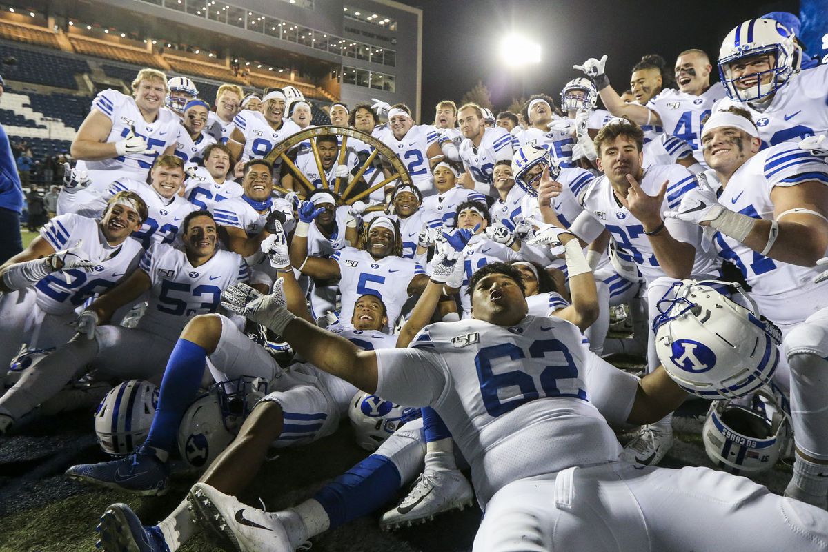The Brigham Young Cougars pose with the wagon wheel following their 42-14 win over the Utah State Aggies in an NCAA football game at Maverik Stadium in Logan on Saturday, Nov. 2, 2019.
