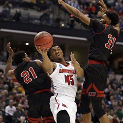 Louisville's Donovan Mitchell (45) heads to the basket as Jacksonville State's Malcolm Drumwright (21) and Christian Cunningham (31) defend during the first half of a first-round game in the men's NCAA college basketball tournament Friday, March 17, 2017, in Indianapolis. Mitchell, recently acquired by the Jazz, will be taking part in the Utah Summer League.