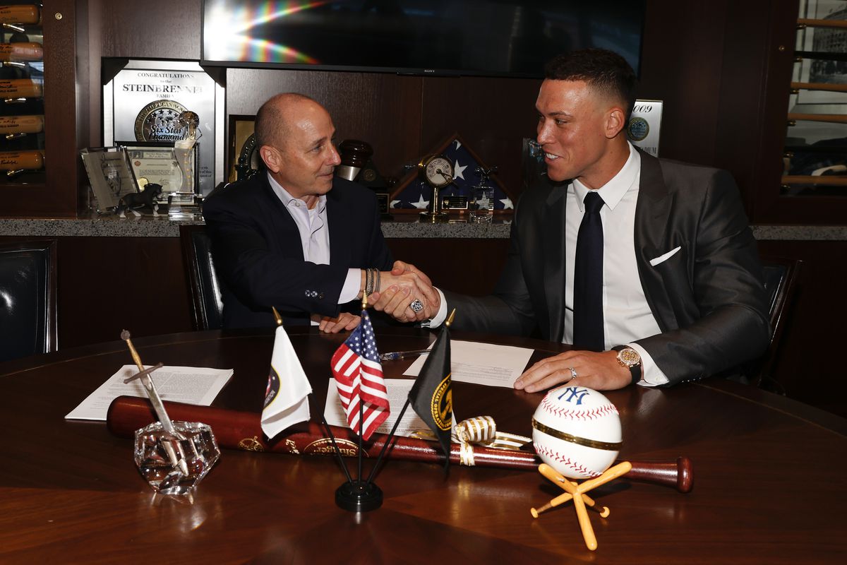 General manager Brian Cashman of the New York Yankees and Aaron Judge #99 finalize Judges nine-year contract before a press conference at Yankee Stadium on December 21, 2022 in the Bronx, New York.