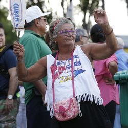 Naisofi Piedra dances and waves a homemade sign made from a Cuban bread wrapper and a stick, as she attends a rally, Wednesday, Nov. 30, 2016, in the Little Havana neighborhood of Miami. Hundreds of Cuban exiles in Miami rallied Wednesday for freedom and democracy on the communist island following the death of revolutionary leader Fidel Castro. 