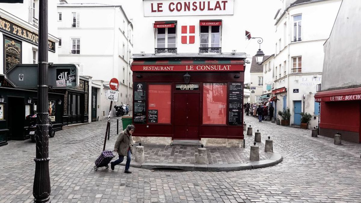 a woman walks past a closed restaurant in Paris