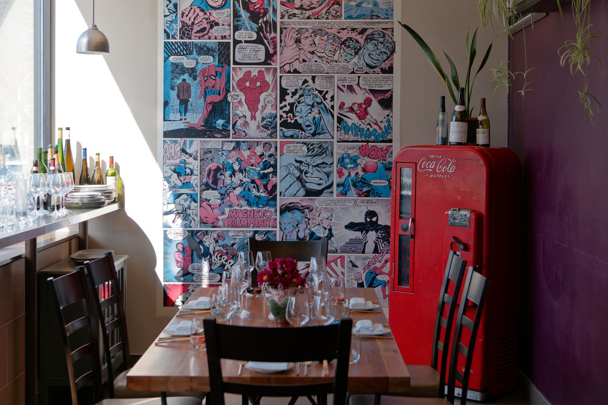 A tiny restaurant space with a wall display of oversize comic book panels.