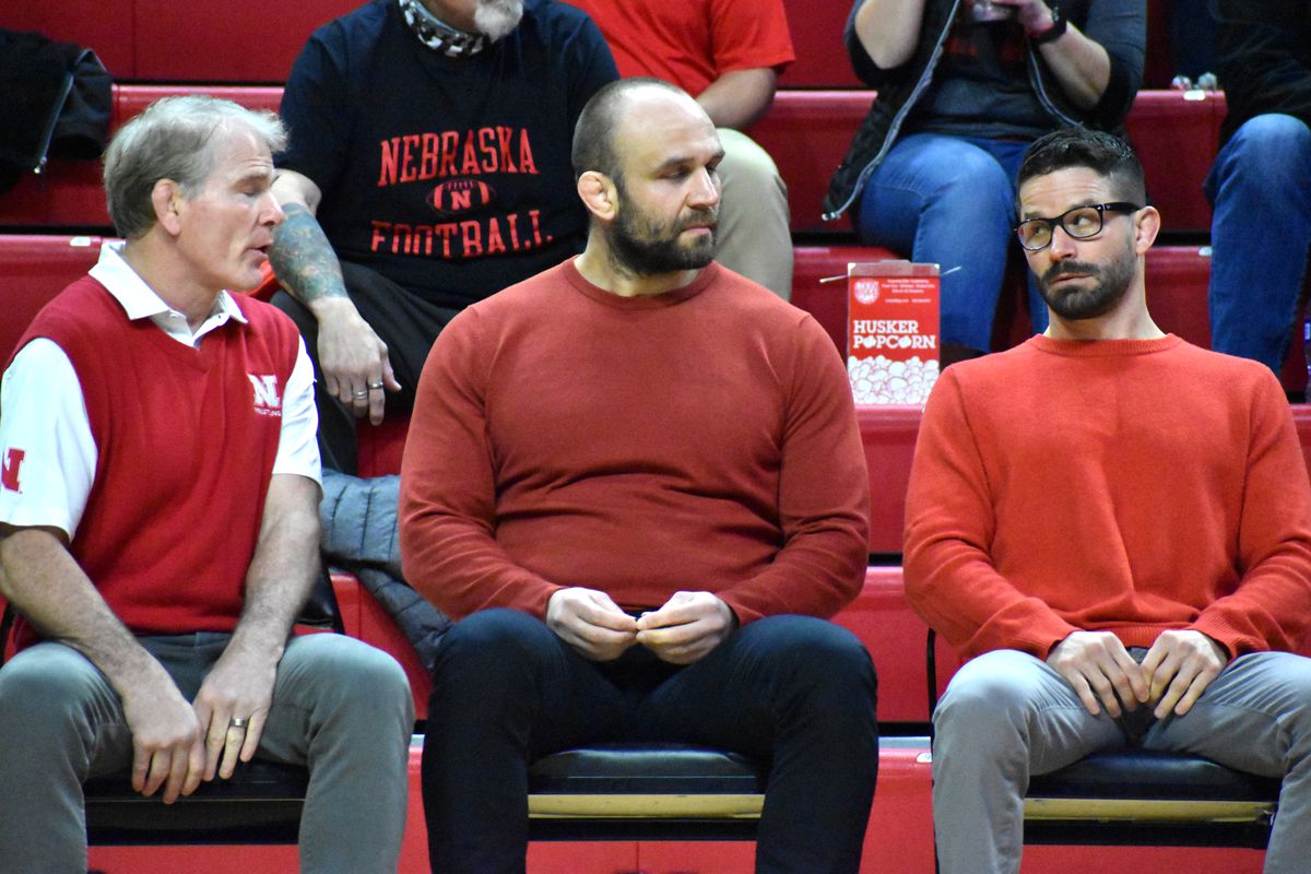 Nebraska Head Coach Mark Manning (left), volunteer assistant Tervel Dlagnev (center), and Associate Head Coach Bryan Snyder (right) talk on the bench during a dual against Illinois on Feb. 13, 2022 at the Bob Devaney Sports Center.