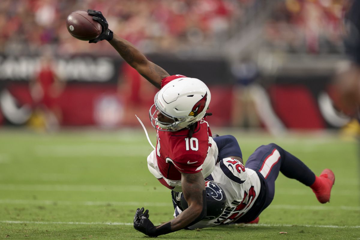 DeAndre Hopkins #10 of the Arizona Cardinals runs with the ball while being tackled by Desmond King II #25 of the Houston Texans in the second quarter in the game at State Farm Stadium on October 24, 2021 in Glendale, Arizona.
