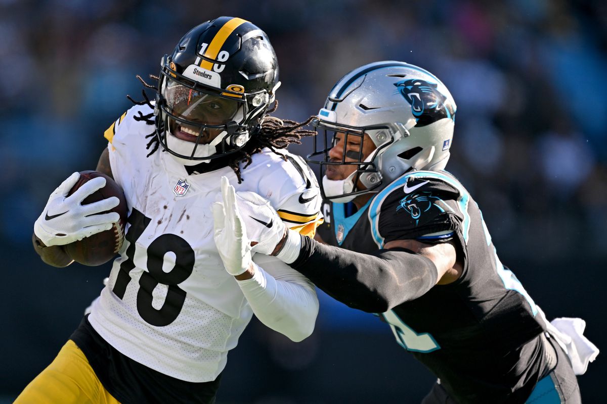 Jeremy Chinn #21 of the Carolina Panthers tackles Diontae Johnson #18 of the Pittsburgh Steelers during the third quarter at Bank of America Stadium on December 18, 2022 in Charlotte, North Carolina.