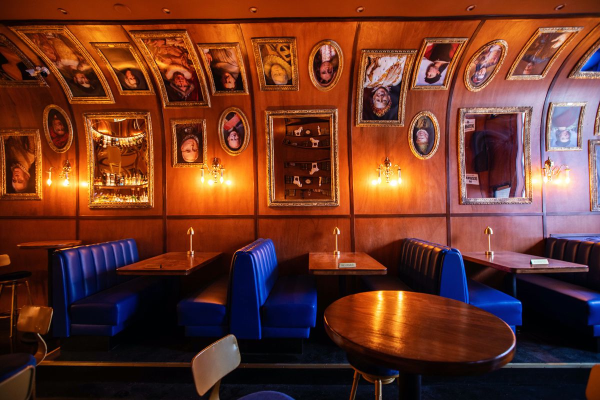 Blue banquette booths, tables, and art at Cold Shoulder bar in Los Angeles.