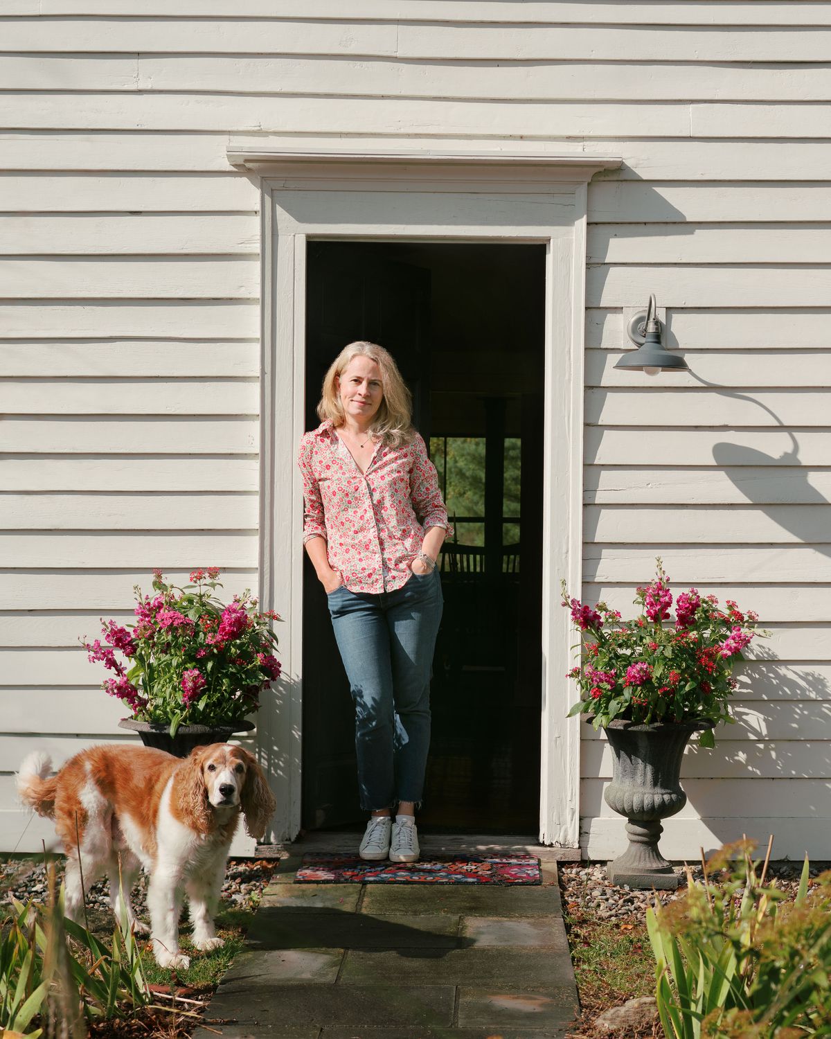 Homeowner standing in the front door with her dog. 