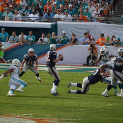 Dec. 15, 2013 Miami Gardens, FL - New England Patriots quarterback Tom Brady (12) steps up in the pocket as Miami Dolphins defensive end Olivier Vernon (50) slips, preventing a sack.