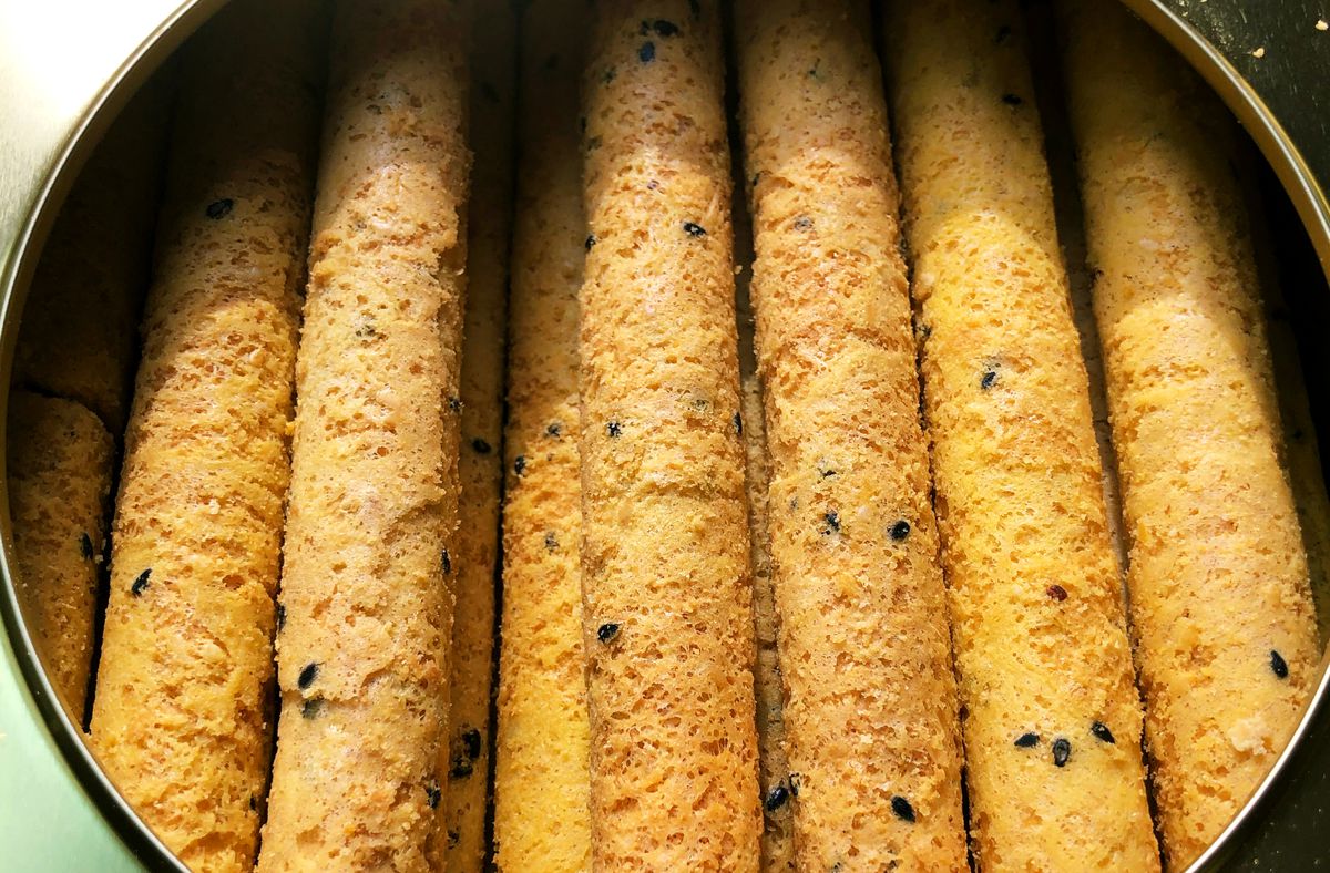 Egg roll cookies lined up inside a tin