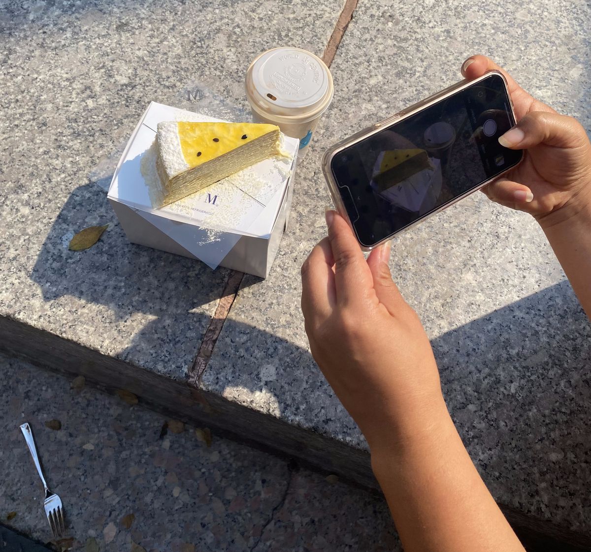 Eater reporter Caroline Shin snaps a photo of a slice of passionfruit mille feuille.