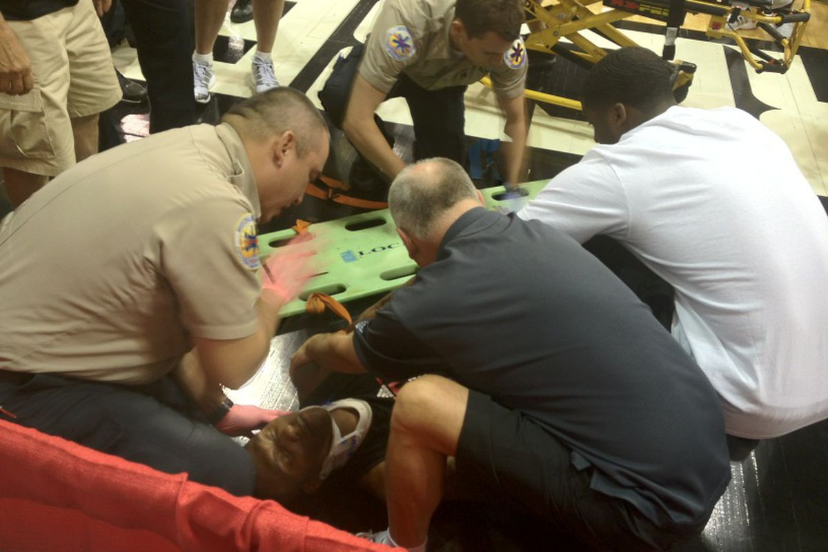 Blazers trainer Jay Jensen and guard Wesley Matthews help Nolan Smith onto a stretcher.