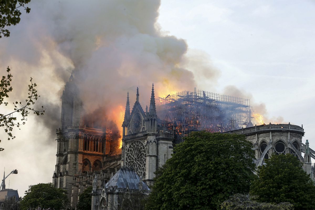 Flames and smoke are seen billowing from the roof of the Notre Dame Cathedral.